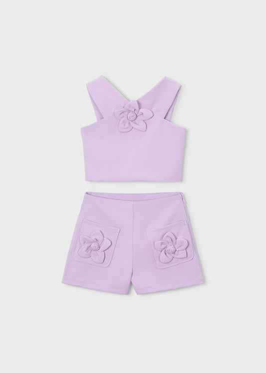 Blumenset mit Mädchen in Bermudashorts